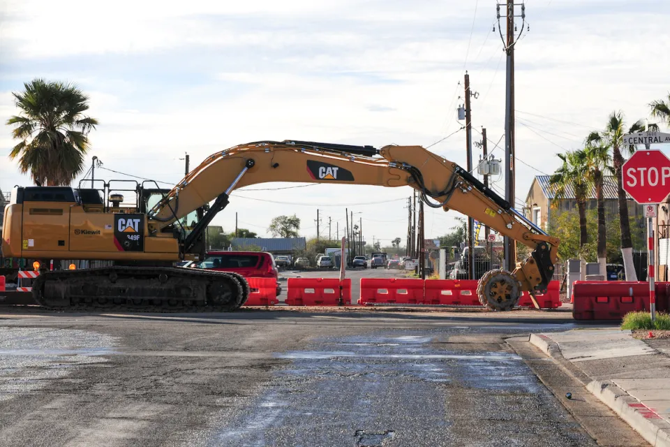 Yellow Cat heavy equipment working on light rail construction on road in Phoenix, Arizona.